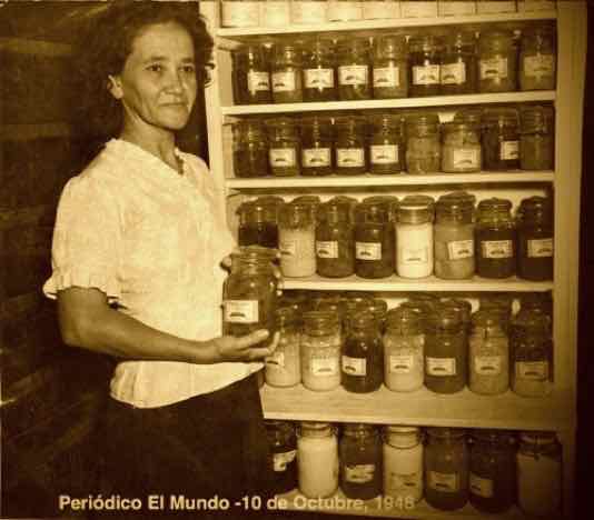 Isabel Pérez, de París, muestra frasco de conserva de piña de su finca (1948)